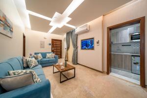 吉达Red Sea Seasons Hotel Suites的客厅配有蓝色的沙发和电视