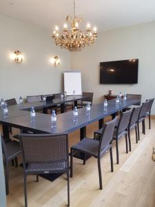 乌尔加特卡宾尼斯酒店的大型会议室,配有大桌子和椅子