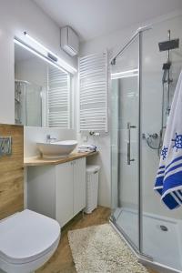索波特Kawalerka z miejscem parkingowym w hali garażowej的一间带玻璃淋浴和水槽的浴室