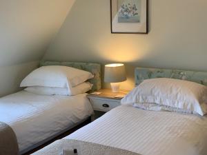 北贝里克Glengair的一间卧室配有两张床和床头灯。