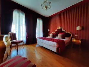 穆拉诺穆拉诺皇宫酒店的一间卧室配有一张红色墙壁的床