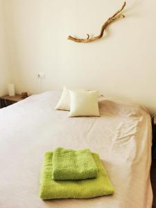 莱斯卡拉Villa Valerie bio & zen的床上的绿毛巾