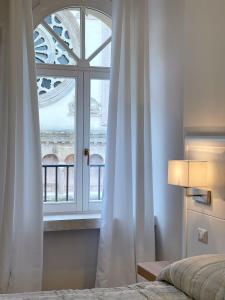 诺切劳恩布拉Residenza San Filippo的一间卧室设有窗户、一张床和床罩