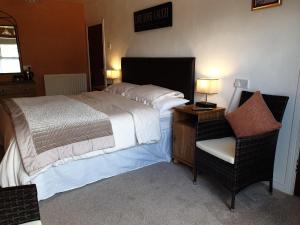 GarvaghGortin Glen Guest House的一间卧室配有一张大床和一把椅子