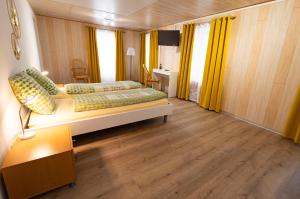 赛尼厄莱吉耶Hôtel Bellavista "Bellevue"的一间卧室设有两张床和黄色窗帘