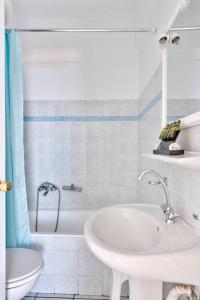 金尼昂APOLLON PALACE的白色的浴室设有浴缸和水槽。
