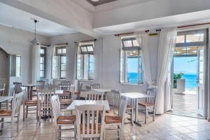 金尼昂APOLLON PALACE的一间带桌椅的海景餐厅