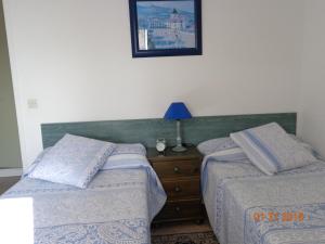 昂代Duplex en Hendaye的一间卧室配有两张床和一个带台灯的梳妆台