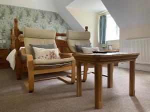 霍舍姆Lancasters Cottage的客厅配有两把椅子和一张桌子