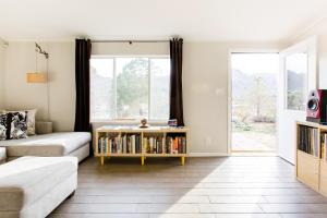约书亚树@ Marbella Lane - 10 Acres Oasis Desert Retreat!的客厅配有沙发和带书籍的书架