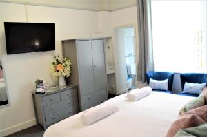 佩恩顿圣埃德蒙兹宾馆的一间卧室设有两张床,墙上配有电视。