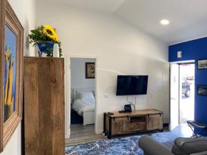 克卢什Casa do Chinelo Azul的带电视的客厅和配有床的房间