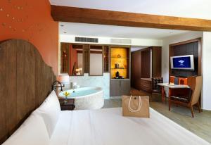 阿文图拉斯港Hard Rock Hotel Riviera Maya度假酒店- 全包的一间卧室配有一张床,浴室设有浴缸