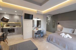 科斯镇Αqua Dream Beach Apartment的一间带一张床和一张书桌的卧室和一间厨房
