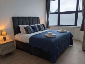 特尔福德Sapphire House Telford的一间卧室配有一张大床和两条毛巾
