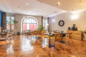 波尔多Hotel de la Presse Bordeaux Centre的一间铺有木地板并配有桌椅的用餐室