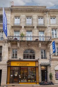 波尔多Hotel de la Presse Bordeaux Centre的前面有商店的建筑