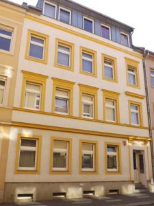 包岑City-Pension-Bautzen的黄色的建筑,街上有很多窗户