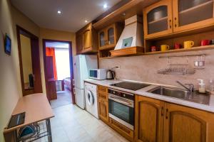 帕莫瑞Константин Асен 1的厨房配有木制橱柜、水槽和洗碗机。