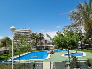 阿利坎特Apartamento con vistas al mar的一座种植了树木和建筑的大型游泳池