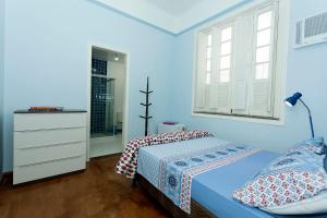 里约热内卢Casa Saga - All Suites的蓝色的卧室设有床和窗户