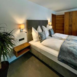 盖洛斯Haus Sonneck的一间卧室配有一张大床和盆栽植物