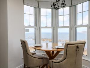 森嫩湾Sennen Heights的一间带桌椅和窗户的用餐室