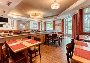 巴特法兴格克尔盘升佛鲁登斯坦酒店的一间带桌椅的餐厅和一间酒吧