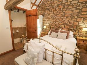 Great OrmsideClove Cottage的一间卧室设有一张床和石墙