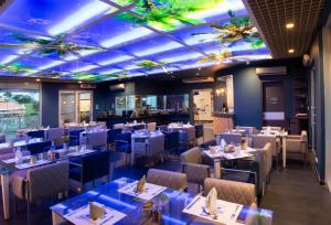 布卡拉曼加Punta Diamante Premium Hotel的餐厅设有桌椅和天花板上的灯光