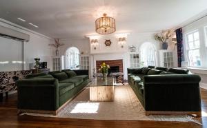 West Cape MayButtonwood Boutique Hotel的客厅配有绿色沙发和桌子