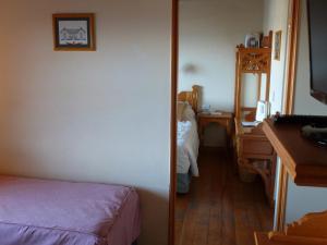 乌斯怀亚潘塔哥尼亚雅尔克旅馆的客房设有带一张床和一张书桌的卧室。