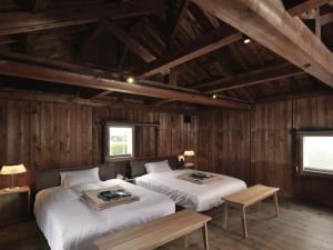 太宰府市HOTEL CULTIA DAZAIFU的木墙客房的两张床