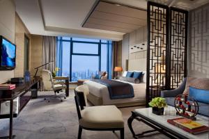 天津唐拉雅秀天津酒店的配有一张床和一张书桌的酒店客房