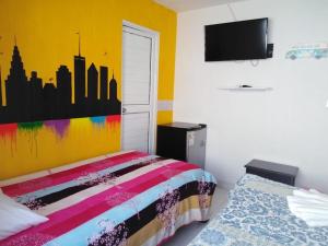 圣安德烈斯Cabañas 7 Colores的一间卧室配有一张色彩缤纷的床和一台电视。