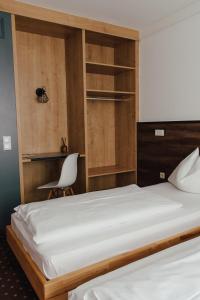 萨尔茨堡德雷克羅伊茨酒店的一间卧室配有一张床、一张桌子和一把椅子