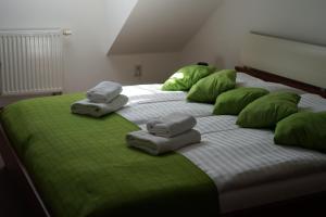 Kojetín匹沃瓦尔斯基酒店的一张带绿色枕头和毛巾的大床