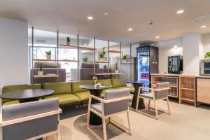 马翁ARTIEM Capri的餐厅设有绿色的沙发和桌椅
