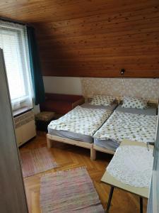 福纽德Fonyód Nyaraló的一间卧室设有两张床和木制天花板