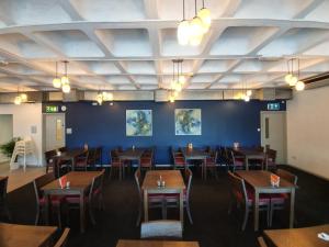 卡迪夫卡迪夫康帕斯柑橘酒店的一间配备有桌椅的用餐室和蓝色的墙壁