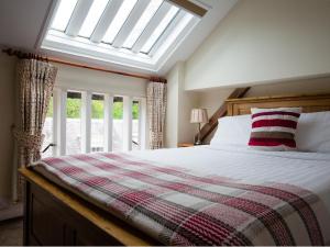 温什科姆Oliver Cromwell的一间卧室配有一张带天窗的大床