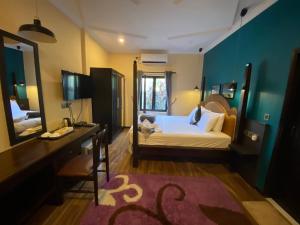 乌库拉斯威利海滩旅馆的一间卧室配有一张床、一张书桌和一面镜子