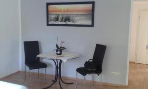 RoggentinFerienhaus - Roggentin的墙上有照片的房间里一张桌子和椅子