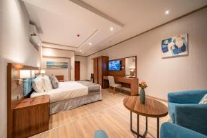 吉达Red Sea Seasons Hotel Suites的配有一张床和一张书桌的酒店客房