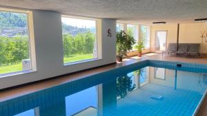 里菲亚诺泰勒红翡膳食公寓酒店的游泳池设有蓝色瓷砖地板和窗户