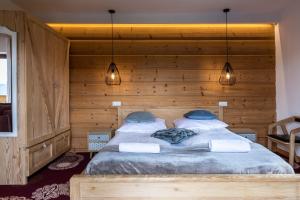 Rzepiskaudanypobyt Dom Forest Prestige House的卧室配有一张木墙内的大床