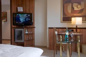 翁纳卡特琳恩霍夫林酒店的配有电视、桌子和床的酒店客房