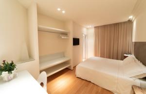 西维尔诺瓦·马尔凯Hotel Country House La Radice的一间酒店客房,配有白色的床和电视