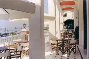 提诺斯提诺斯酒店的阳台配有桌椅,享有海景。