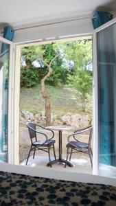 格雷乌莱班Le Moulin du Verdon的窗前的两把椅子和一张桌子